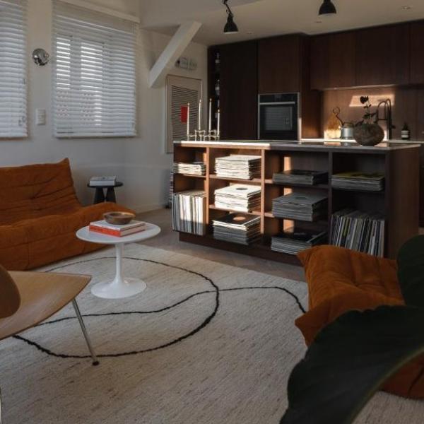 Salon ouvert dans le style de décoration Mid-Century avec un tapis clair au design de lignes noires.